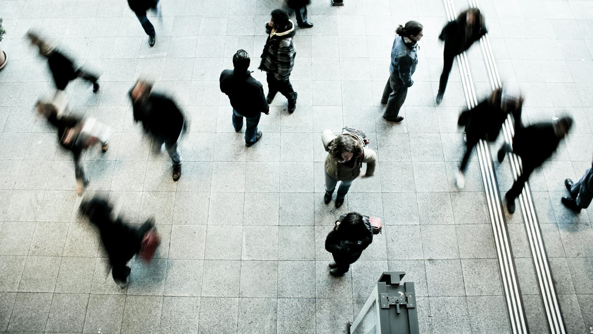 People walking across a concourse seen from above, with head-detection boxes